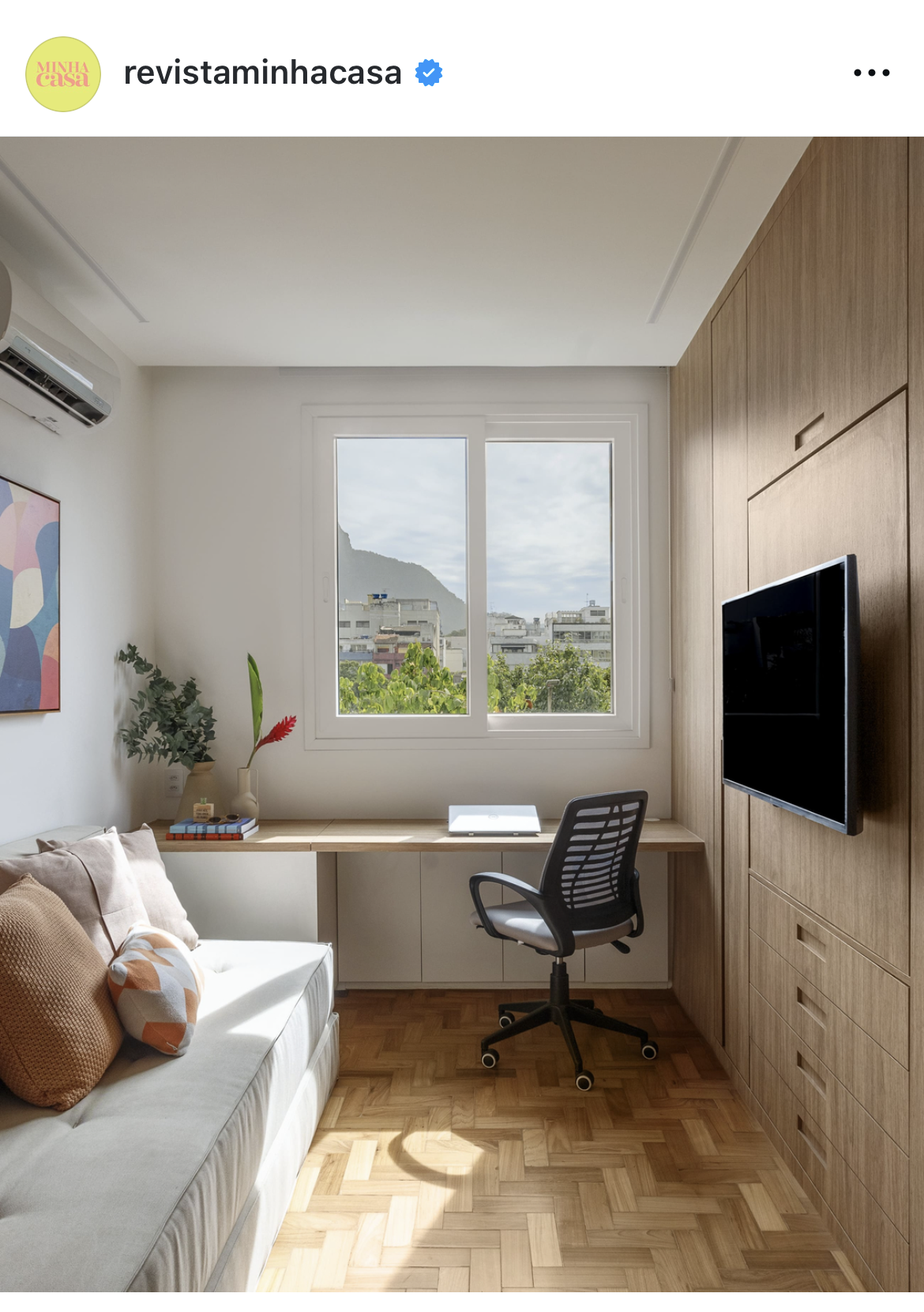 A narrow, cozy living room with a small couch, table, and soft window light