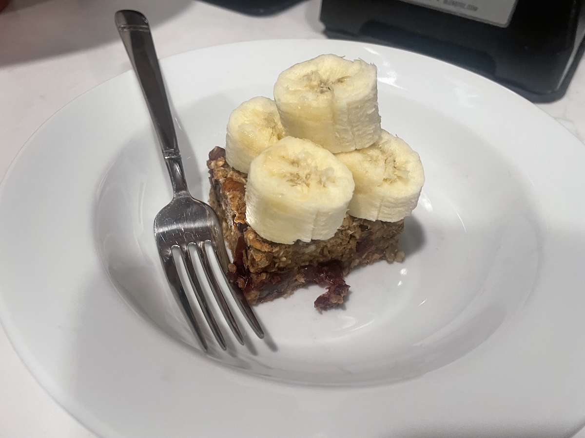 Oatmeal loaf topped with sliced bananas on a plate