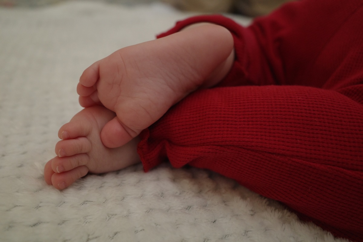 Baby’s feet resting on a table during a family holiday gathering